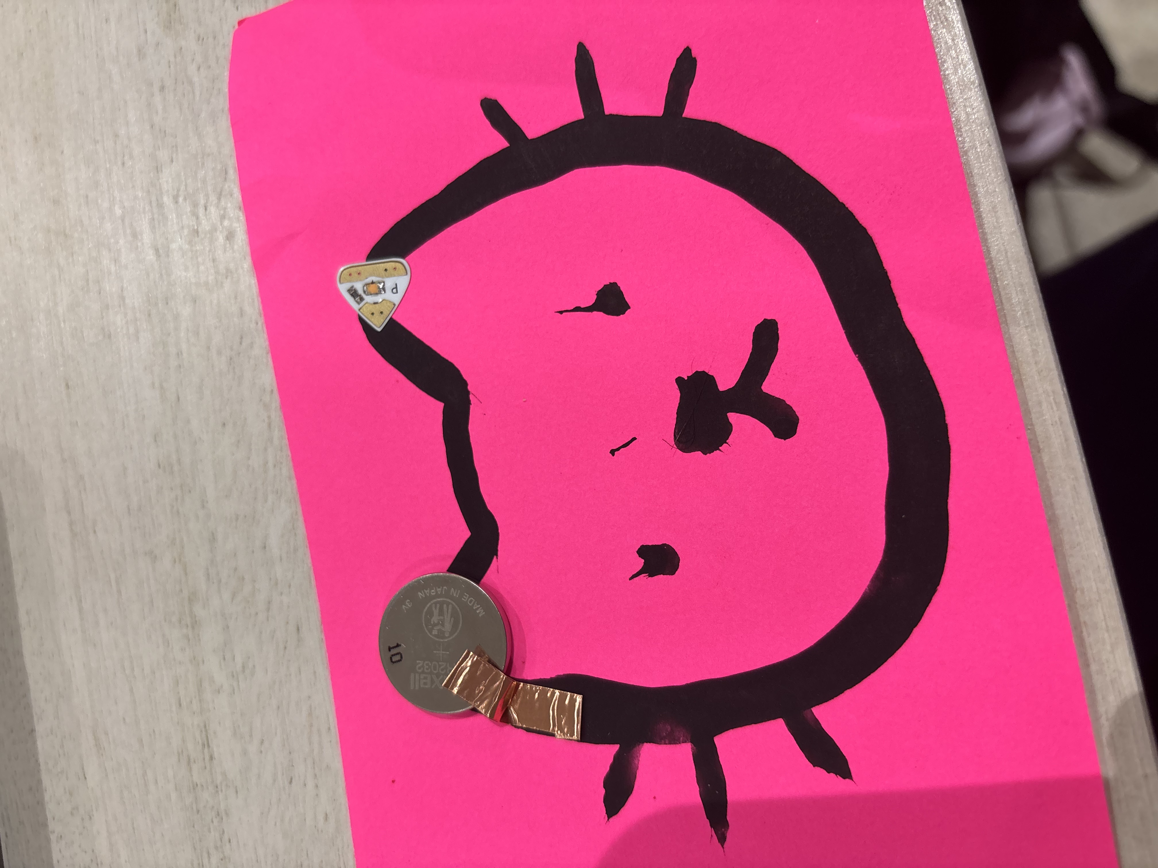 Paint circuit with conductive paint, a battery, and a light bulb.