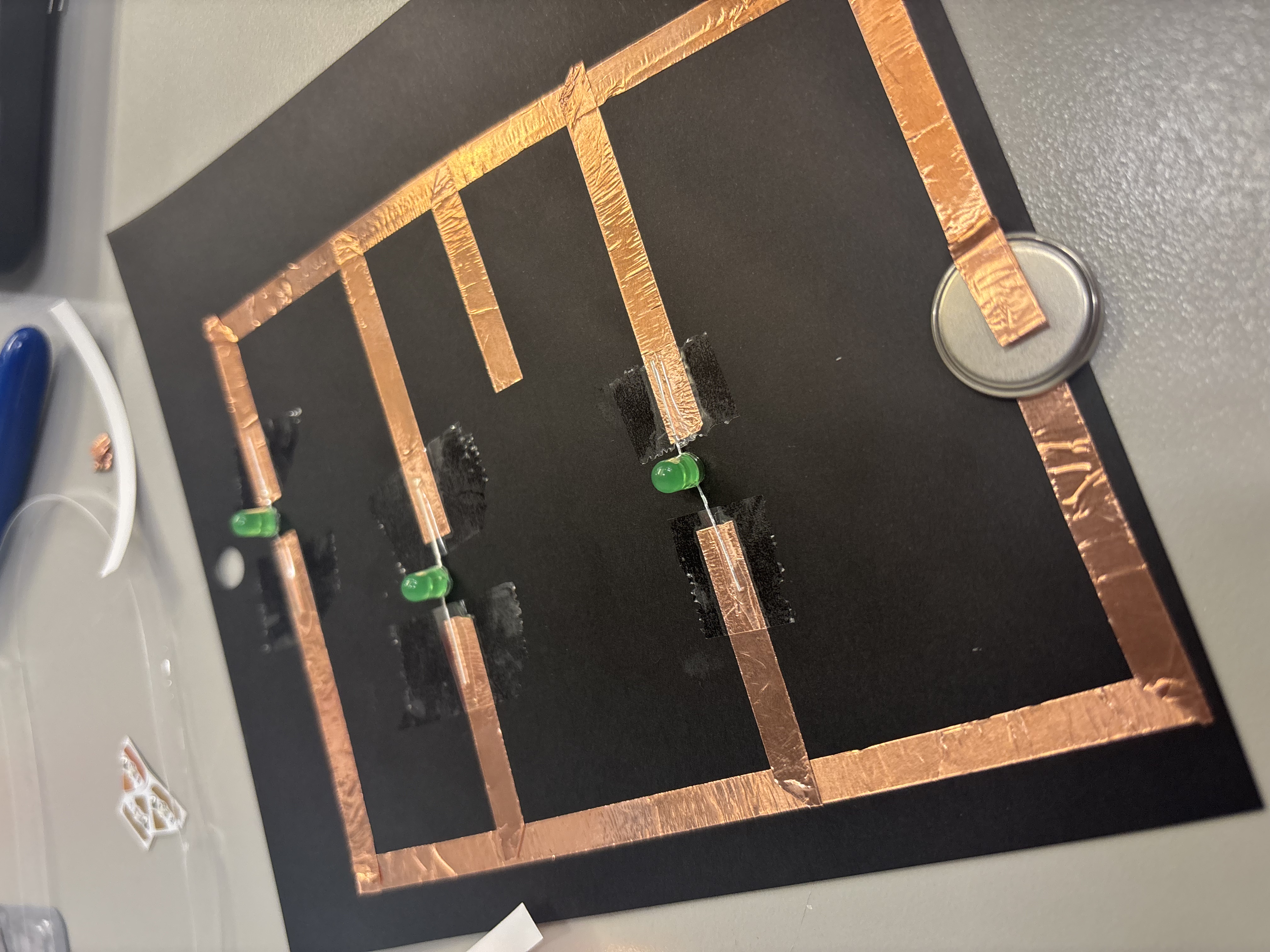 First paper circuit using copper tape, a battery, and three lights.
